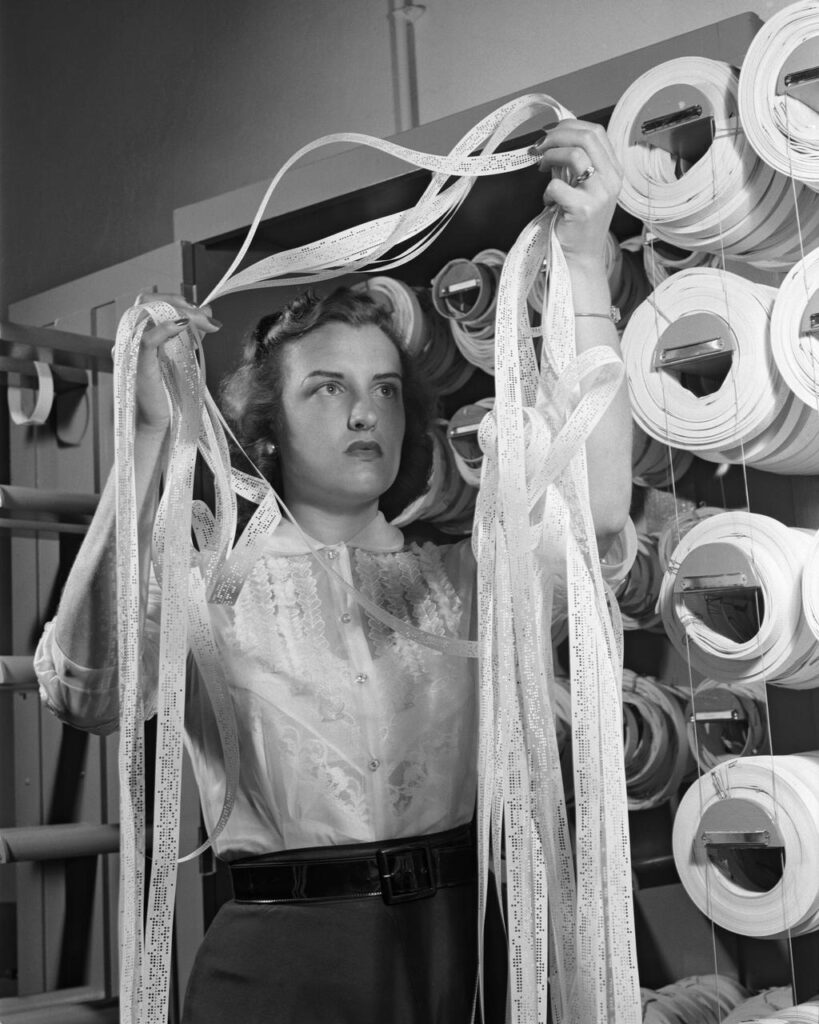 White woman handling tangled Manometertape for a Bell computer.